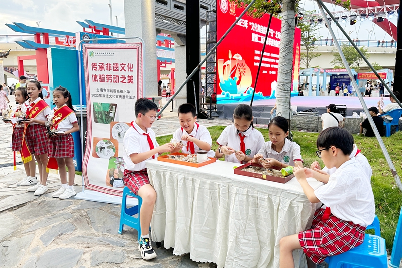 在“文化和自然遺產(chǎn)日”北海市非遺宣傳展示暨第二屆北海非遺購(gòu)物節(jié)上，小朋友正在體驗(yàn)非遺工藝品制作。_副本.jpg